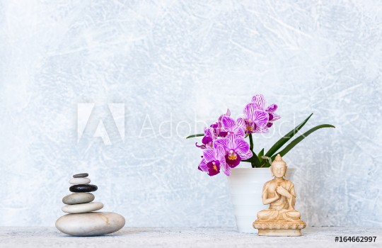 Bild på Buddha pyramid of pebbles and orchid flower as zen background